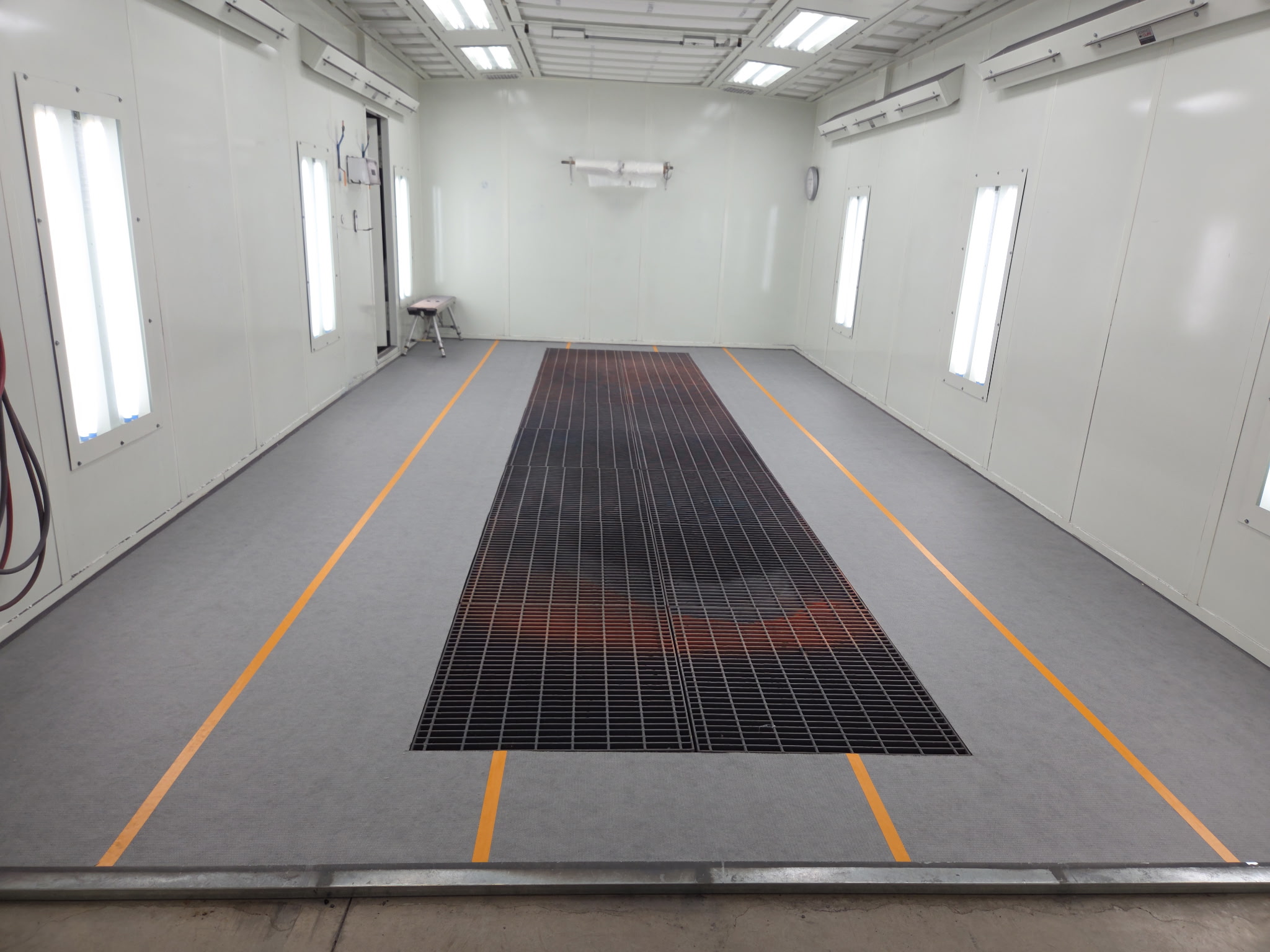 Clean, empty paint booth interior with central floor grating