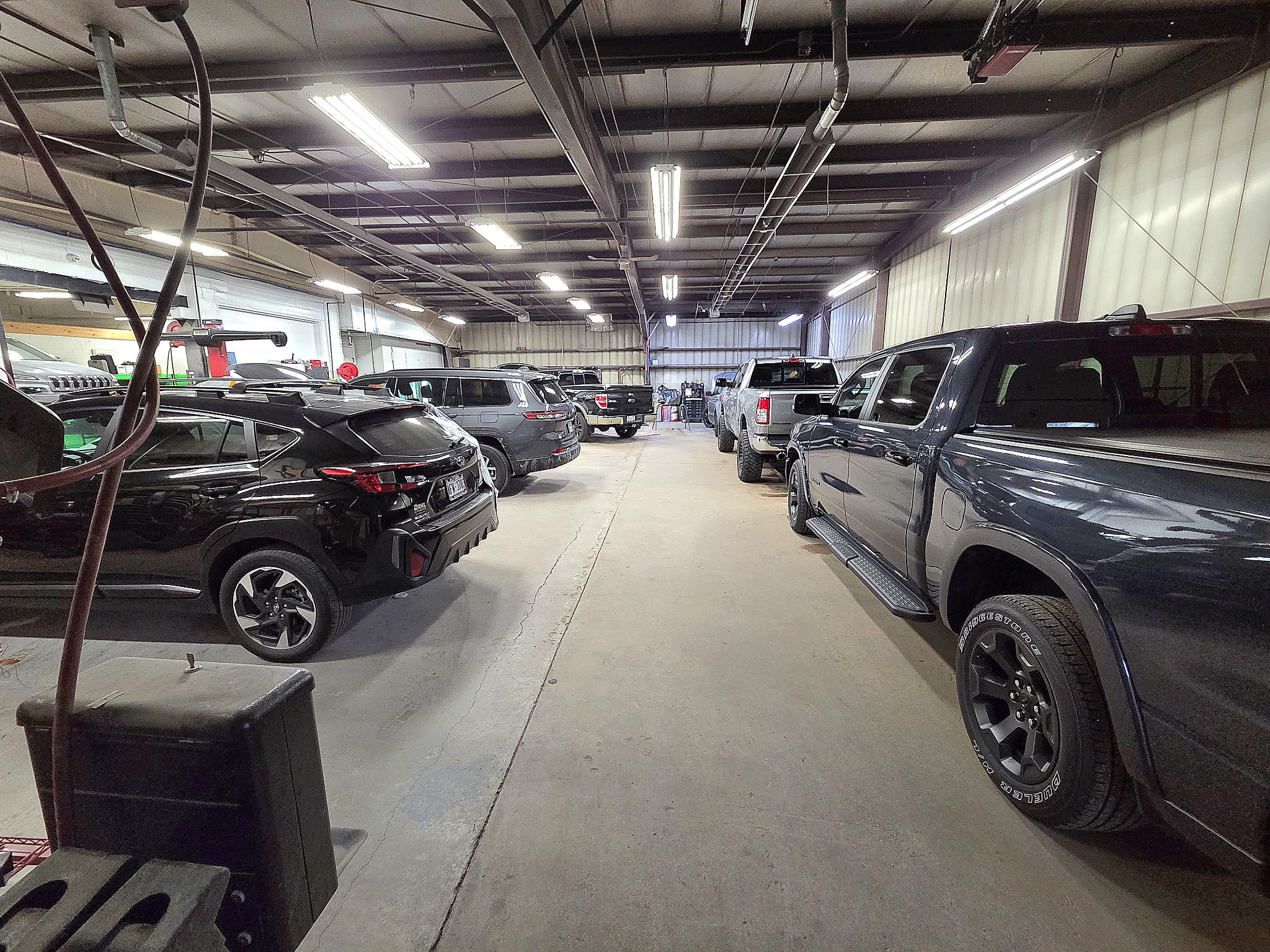 Rows of customer vehicles parked in the shop work bay