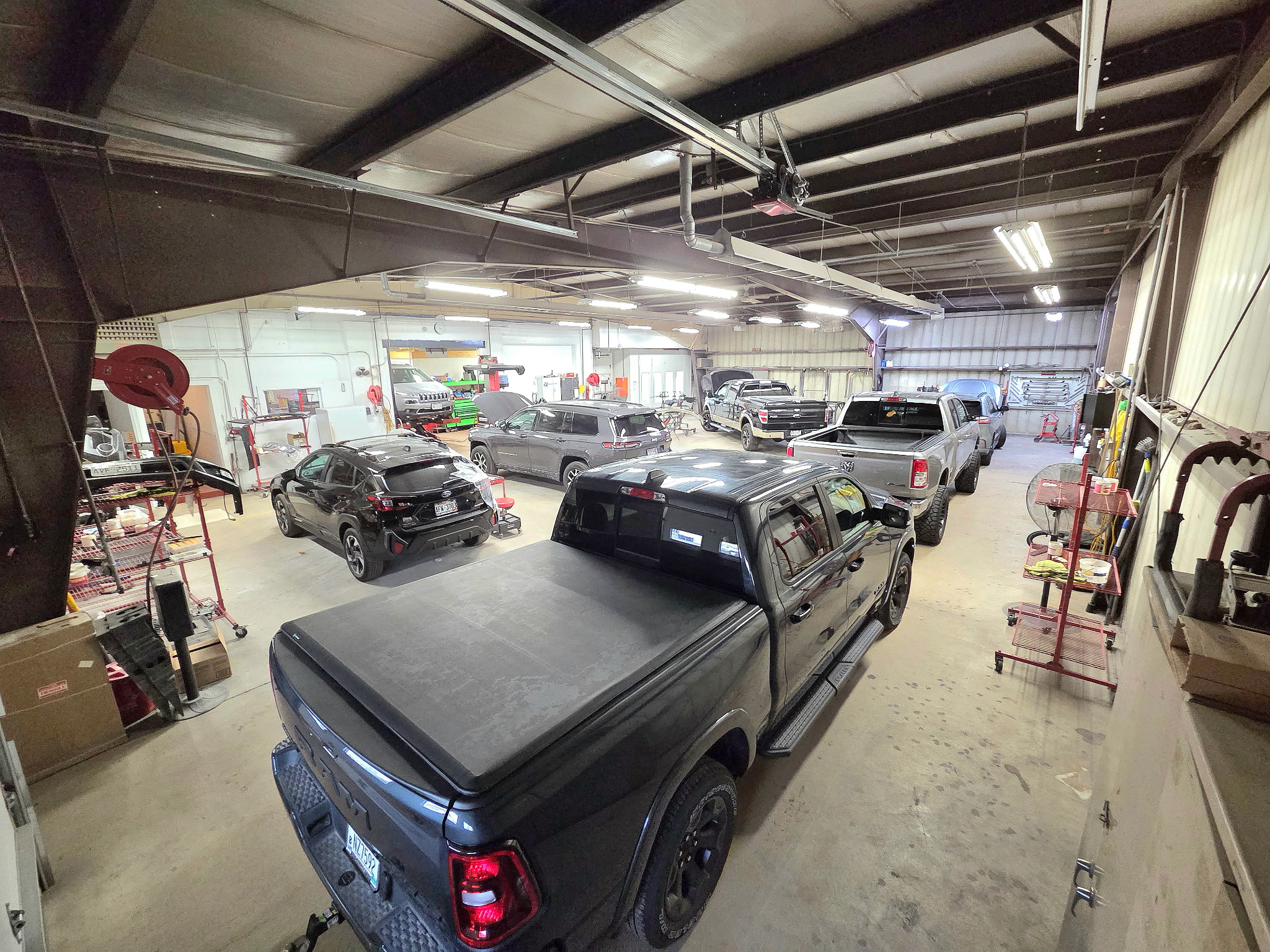 Elevated view of the shop interior with several vehicles being worked on